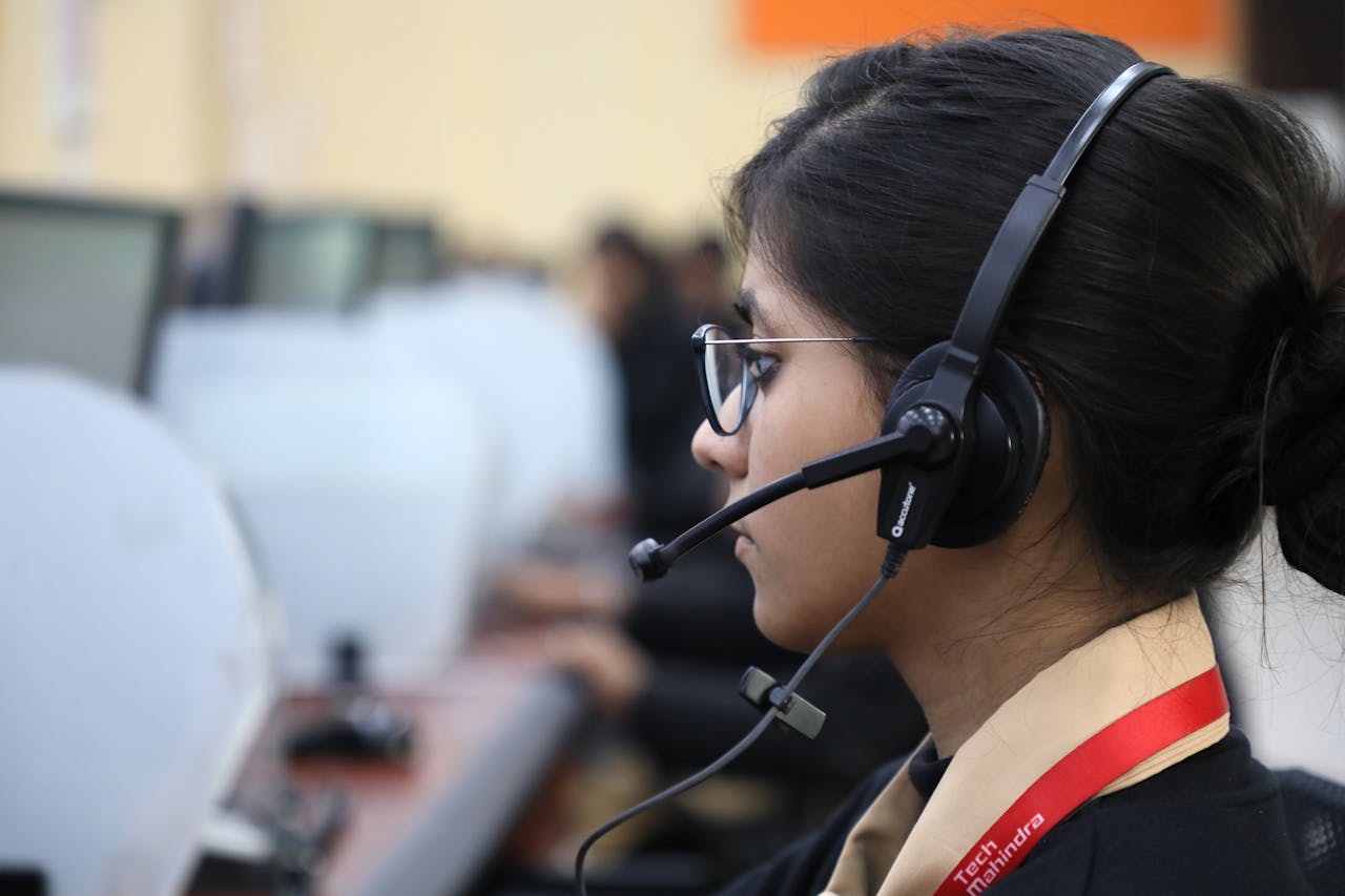 The Art of Drawing Readers In: Your attractive post title goes here Side view of a woman working in a call center, wearing a headset and focused on her task.